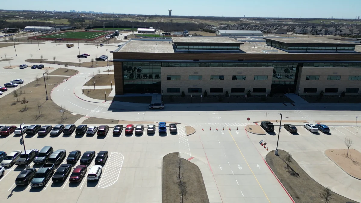 Aerial view of a Frisco school campus, parking area, and athletic fields